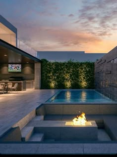 a fire pit in the middle of a patio with a tv on it's wall