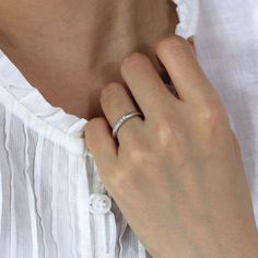 a woman wearing a wedding ring on her left hand