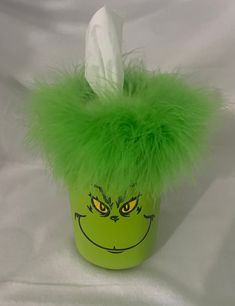 a green cup with a grin face painted on it