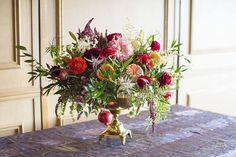 a vase filled with lots of flowers on top of a table