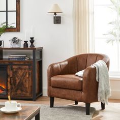 a living room with a chair, fireplace and mirror on the wall next to it