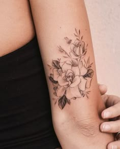 a woman's arm with a flower tattoo on the left side of her arm