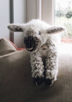 a stuffed sheep sitting on top of a couch