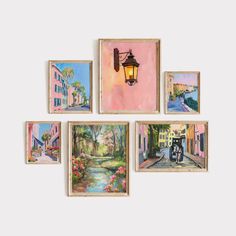 six paintings hang on the wall in front of a lamppost with a street scene