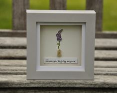 a white frame with a purple flower in it