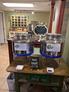 two large metal pots sitting on top of a table next to a sign that says most popular