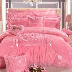 a pink bed with ruffled bedspread and pillows