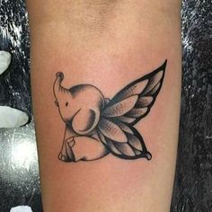 an elephant with wings tattoo on the leg