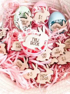 a basket filled with lots of pink and blue easter eggs next to tags that say new book