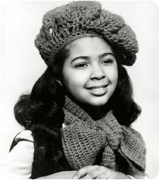 an old black and white photo of a woman wearing a knitted hat with a bow