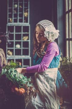 A Kim Winey Photography photo of a young girl, in a potting shed, working on a fall harvest. Photo Session