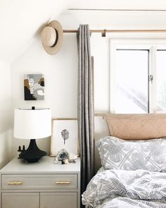 a bedroom with a bed, dresser and window