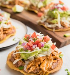 some tacos are sitting on plates and ready to be eaten