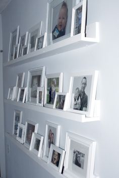 several white shelves with pictures and frames on them, all displaying baby's photos