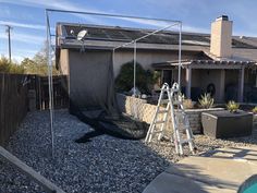 a house with a pool in the yard and a ladder up to it's roof