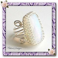 a ring with an oval shaped white stone in the middle and spiral wire around it