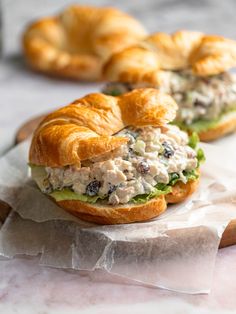 two croissant sandwiches with chicken salad on them