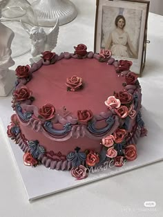 there is a cake with roses on it and an angel figurine next to it