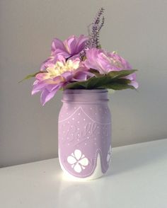 a purple mason jar with flowers in it