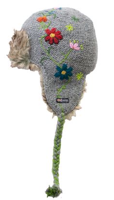 Part of the 2020 collection: The Reshma Earflap is a half faux fur-lined earflap. It combines the tassels of our classic earflap with the comfort and style of our fur hats. The reverse-knit base is topped with hand-embroider flowers down one side. The green embroidered stem meets the tassels of the hat and is braided in. The Reshma's Earflap also features a faux fur accent at the front. Like all of our wool products, the Reshma Earflap is: 100% New Zealand wool Hand-dyed Hand-knitted Unique to y Adjustable Winter Hat With Feather Trim, Winter Hat With Feather Trim, Winter Faux Fur Hats With Ear Flaps, Faux Fur Winter Hat With Ear Flaps, Winter Hats With Faux Fur Trim And Ear Flaps, Floral Beanie, Wool Products, Fur Hats, Hand Embroidered Flowers