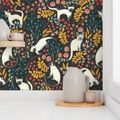 a wallpaper with cats and flowers on it in a room that is painted black