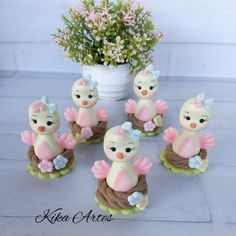 a group of small figurines sitting next to a potted plant