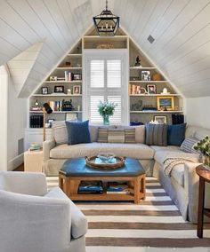 a living room filled with furniture and lots of shelves on the wall next to a window