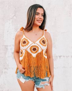 The Sunflower Fringe Crochet Top is the perfect boho cottage core girl piece! Layer it over a bralette for the coolest boho chic look!  It features a cropped fit on the crocheted sunflower portion, and the fringe will hit below the belly button. It's such a one-of-a-kind unique piece for your wardrobe.   This piece is handmade with obscene amounts of love, so sizing and color placement will vary slightly. In terms of sizing, this piece will comfortably fit S-XL, as it has an adjustable tie in the back! We recommend hand washing and hanging to dry! Boho crochet top | boho style crochet clothing | cottage core apparel Bohemian Crop Top For Music Festival, Hippie Cotton Crochet Top For Beach, Spring Bohemian Crochet Top With Granny Square, Bohemian Crochet Lace Crop Top For Beach, Bohemian Crochet Lace Crop Top For Beach Season, Bohemian Crochet Top With Granny Square For Spring, Summer Crochet Top With Granny Square For Vacation, Bohemian Sleeveless Crochet Top With Crochet Trim, Bohemian Granny Square Crochet Top For Beach