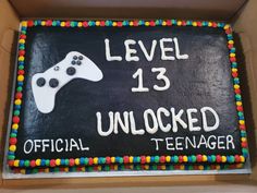 a birthday cake with a video game controller on the front and words level 13 unlocked