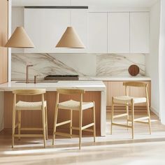 three stools sit in front of an island with marble counter tops and lamps on it