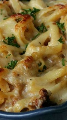 a casserole dish with meat, cheese and parsley in a blue bowl