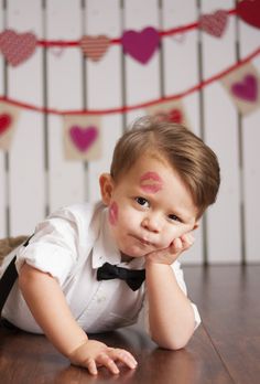 a little boy laying on the floor with his hands under his chin