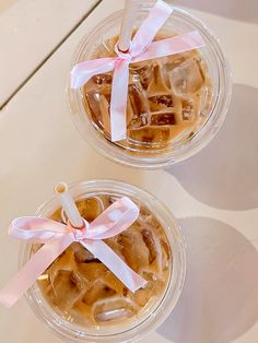 two cups filled with ice cream sitting on top of a white table next to each other