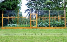 the garden is fenced off with metal bars and orange posts that are attached to each other