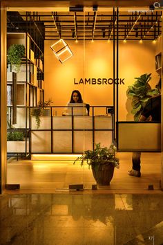 a woman sitting at a desk in front of a plant