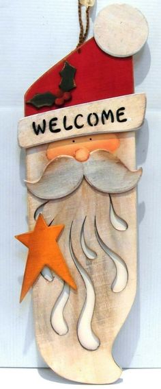 a wooden sign that says welcome with a santa clause on it's hat and star