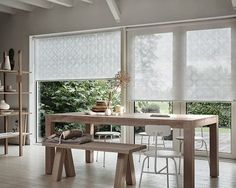 a dining room table with two benches in front of it and an open window to the outside