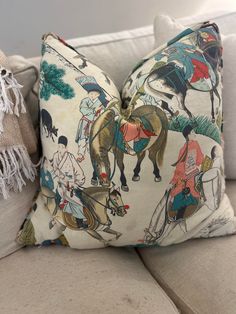 two pillows on the back of a couch with horses and men in traditional chinese clothing