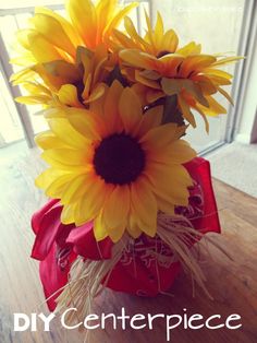 a vase filled with sunflowers on top of a wooden table