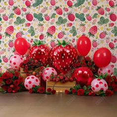 a table topped with lots of red balloons and strawberries