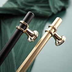 a gold and black umbrella stand next to a green cloth