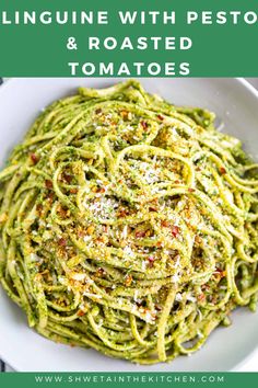 linguini with pesto and roasted tomatoes in a white bowl on a table