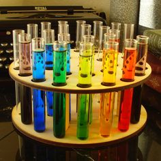 there are many test tubes with colored liquids in them on the table next to an old radio