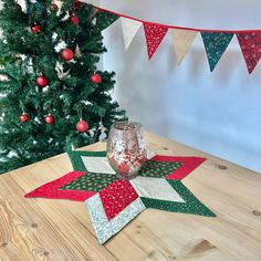 a wooden table topped with christmas decorations and a wine glass filled with liquid sitting on top of it