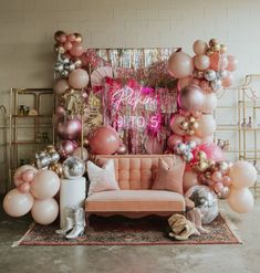 a couch sitting in front of a wall filled with balloons