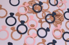 some pink and blue glittered scissors on a white surface with gold sequins