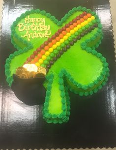 there is a green cake decorated with a shamrock and some gold coins on the side