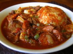 a white bowl filled with meat and vegetables