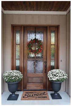 the front door is decorated with wreaths and flowers