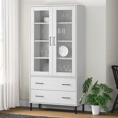 a white china cabinet with glass doors and drawers next to a potted green plant